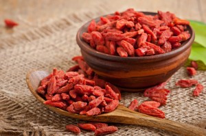 Red dried goji berries in wooden spoon